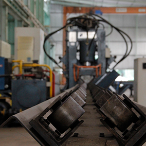 ="Imagem da galeria de imagem da página de Energia. A imagem mostra um equipamento na fábrica de produção de torres de transmissão de energia.